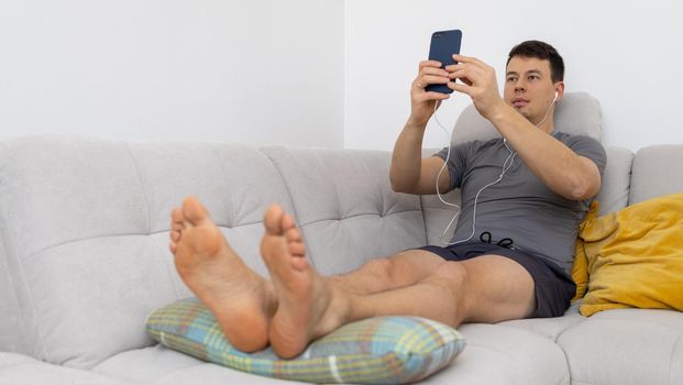 young man in headphones watching at mobile phone. High quality photo