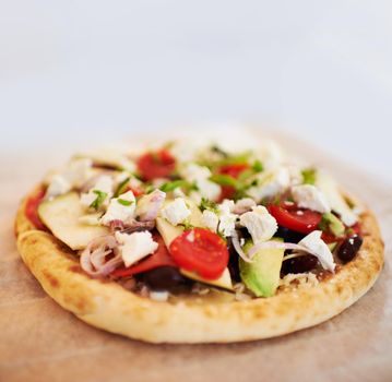 A tasty pita bread topped with a range of fresh ingredients.