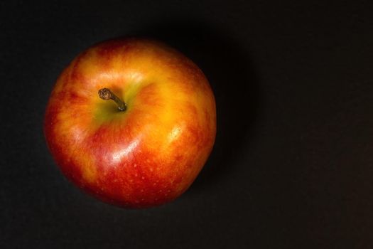 Ripe red apple on a dark background with copyspace