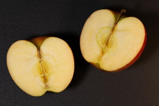 Ripe red apples on a dark background, apple cut in half