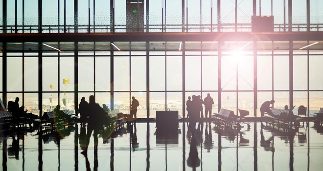 Shot of a group of unidentifiable travelers in the waiting area of an airport.