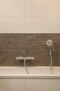 The interior of a bathroom in a modern house decorated with tiles with a bathtub