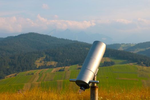 Large binoculars for viewing into the distance against the backdrop of the mountains