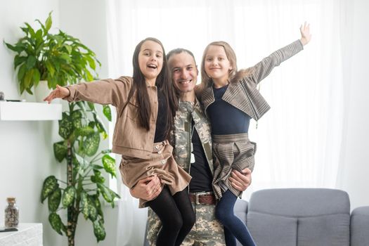 Happy military father and two daughters at home