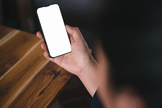 Mockup Image of Woman's Hands is Using Smartphone With Empty White Screen for Coppy Space on Office Desk. Digital Mobile Phone Portable and Technology Internet Communication Connection Concept.