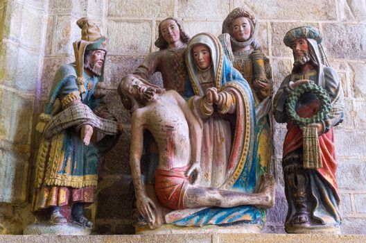 Locronan, France - august 10 2017: Penity Chapel: Descent from the Cross and Mourning (Sculpture XVI century) Chiseled masterpiece in granite, tomb of Saint Ronan.