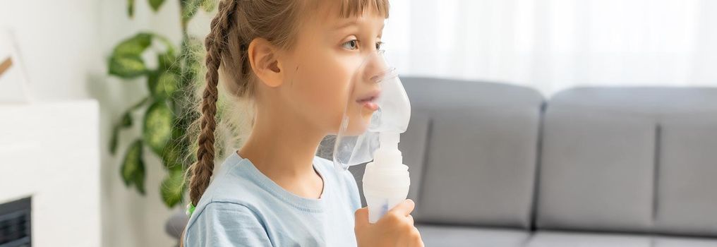 Little girl making inhalation with nebulizer at home. child asthma inhaler inhalation nebulizer steam sick cough concept