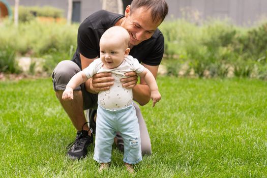 Father and his son walking at summer park.