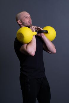 Guy with a yellow kettlebell gym anonymous yellow man, in the afternoon motivation effort in training and floor youth, vietnamese activity. Healthy bent health, cross hiit