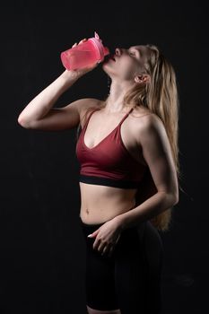 Hand in shaker spotrsman pink girl a her holds in black background shaker pink black caucasian, for gym lifestyle for person for bodybuilding athlete, beautiful people. Sweat ABS