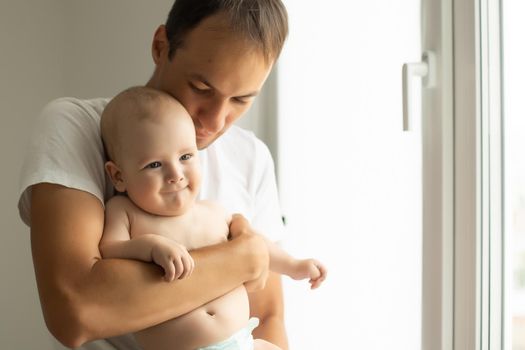 Happy middle age man holding his little baby.