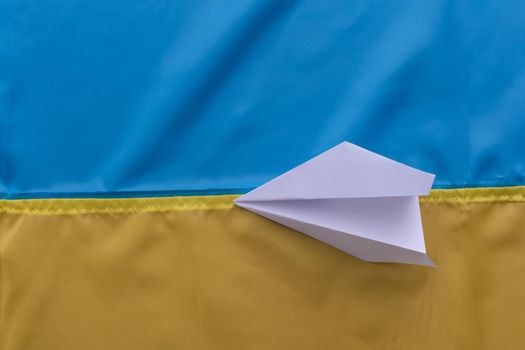 paper airplane on the background flag of Ukraine, flags of the country, blue, yellow.