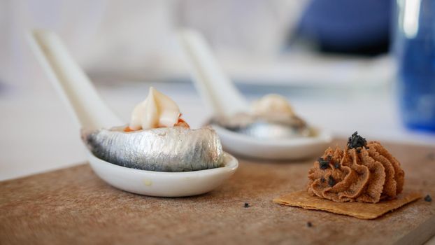 Closeup of spanish tapa with anchovy over spoon