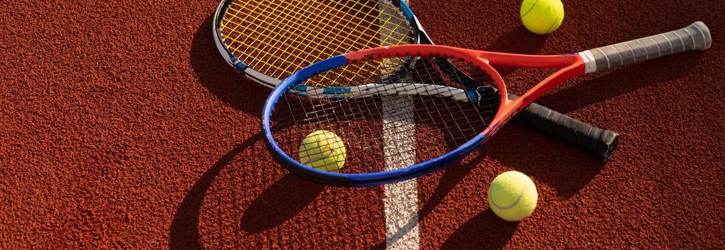 Close up view of two tennis rackets and balls on the tennis court