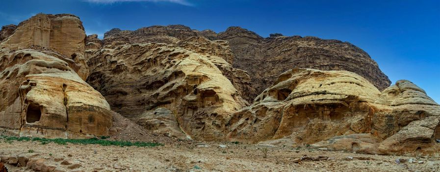 Wadi Rum rocky desert with red sand and red rocky mountains, sand dunes blue sky