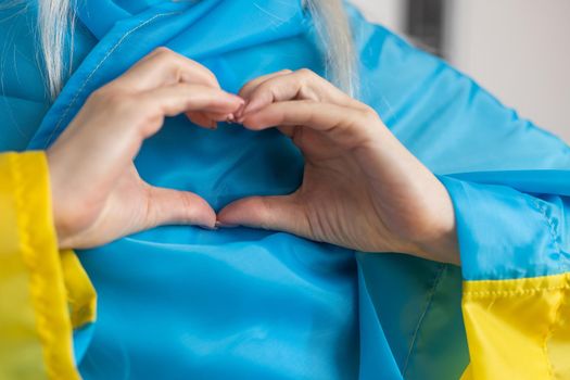 The concept of ending the war in Ukraine. heart in the colors of the flag of Ukraine in female hands