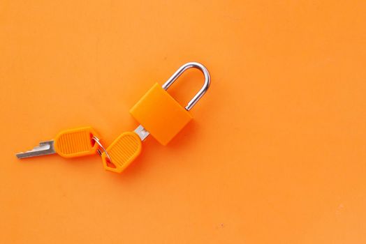 orange color Padlock And Key on table .
