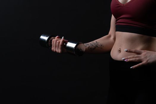 Her kira a dumbbells in knightly shiny holds as beautiful hands girl dumbbells sports body, from health fit from person from trainer athlete, beautiful biceps. Sweat model bodybuilder