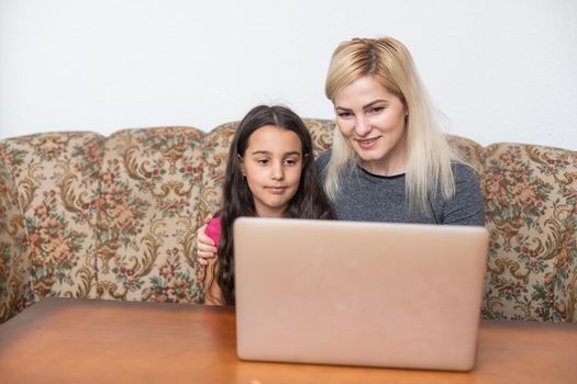 Happy family Mother and daughter watching videe entertainment with laptop computer technology the living room enjoy life at home concept.