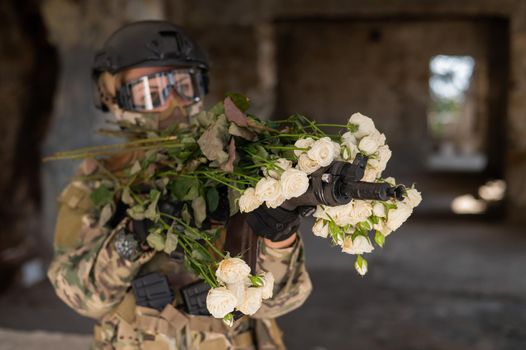 Caucasian woman in military uniform holding a machine gun and a bouquet of white roses