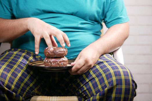 young man open his mouth eating donut , selective focus