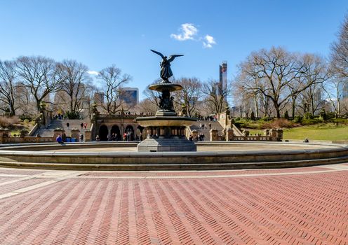Bethesda Fountain with Angel of the Waters Sculpture rear view, Central Park New York during winter with clear sky, lots of people walking in the background, horizontal
