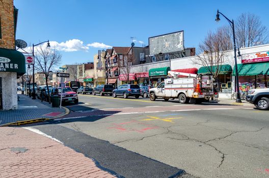 Retail Stores at Center of the City near Cliffside Park, New Jersey, during a sunny winter day, lot of cars parked next to the stores on the street, horizontal