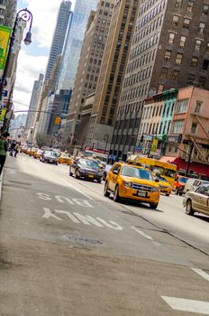 Only Bus Street in front of traffic, lots of yellow taxi cabs and cars in Manhattan New York City, skyscraper in the background, artistically composition, vertical