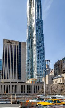 Pace University Building with Brooklyn bridge street and traffic in the forefront during daytime at New York City, vertical