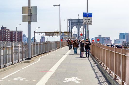 People standing and walking on Brooklyn Bridge, New York City during daytime, horizontal