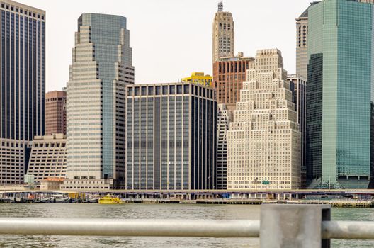 Skyline of Manhattan view from waterfront from Brooklyn steel fence in the forefront, New York City, during winter, horizontal