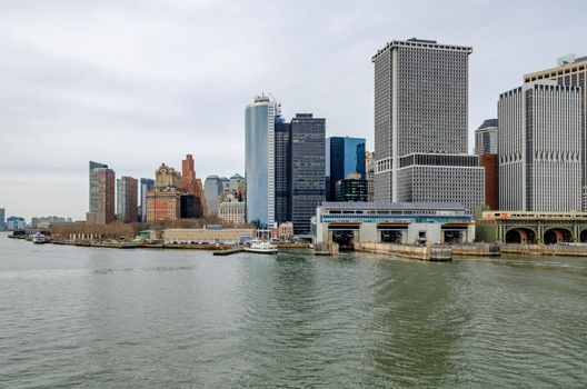 Manhattan, New York City with Staten Island Ferry Battery Maritime Building Slip 5 in forefront, during winter day with overcast, horizontal