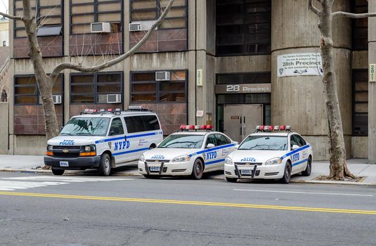 NYPD Different New York Police Department cars and trucks parked next to each other at a police station in Harlem next to the street, New York City, during winter day, horizontal