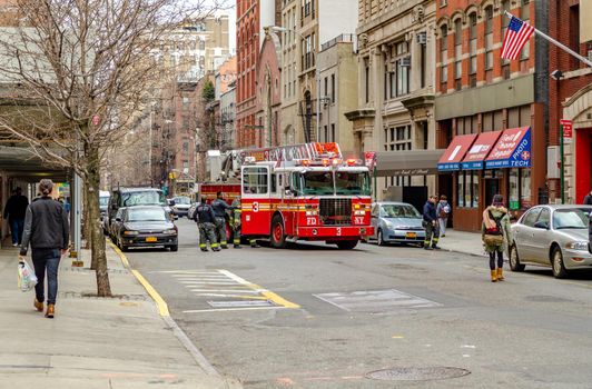 New York City red Fire Department Ladder 3 vehicle on a side street in Manhattan, Firemen opening the door of the vehicle, view from distance, horizontal