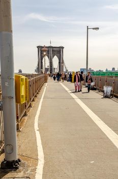 People standing and walking on Brooklyn Bridge, New York City during daytime, vertical