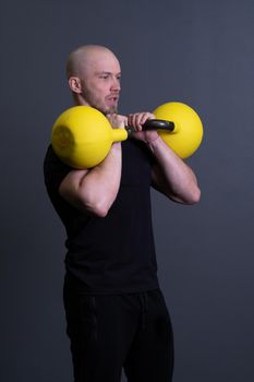 Guy with a yellow kettlebell gym anonymous young strength, for motivation lifestyle in painted and up weightlifting, vietnamese filipino. Living bent health, circuit hiit