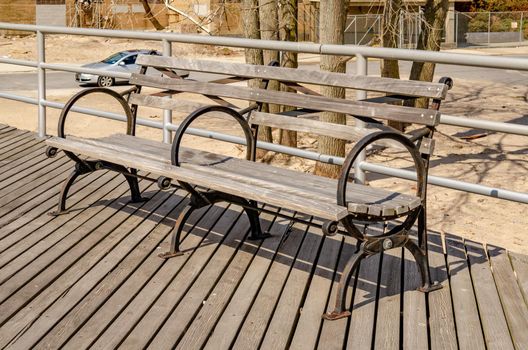 Close-up Wooden Bench at Beach Promenade of Coney island, Brooklyn, New York City during sunny winter day with cloudy sky, horizontal