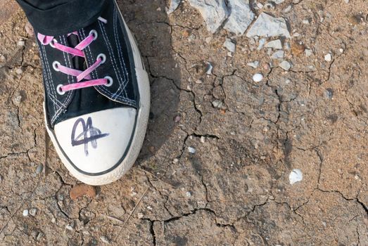 Punk emo girl black and white chuck shoe with pink shoelaces, outdoors, horizontal