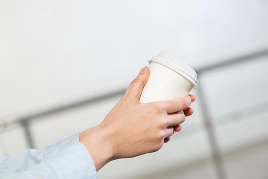 close-up of women's hands with a cup of coffee. break during work