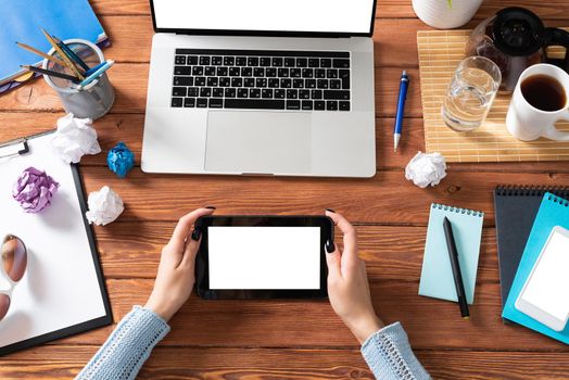 Businesswoman using tablet computer at office desk. Internet communication and commerce. Flat lay office workplace with female hands and laptop. Digital technology and mobile application for business