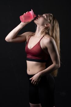 Her spotrsman hand girl in a shaker pink holds in black background shaker pink black caucasian, for female lifestyle from healthy from active isolated, beautiful wellness. Sweat ABS body