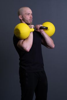 Guy with a yellow kettlebell gym anonymous workout man, from fit lifestyle for painted and rubber youth, vietnamese fitness. Living bent health, club hiit