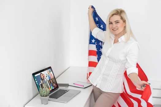 woman with american flag sits on laptop in living room