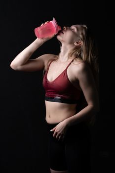 Holds spotrsman her hand in pink girl shaker a in black background shaker pink fitness workout, In the afternoon gym lifestyle for person and active isolated, sexy biceps. Sweat model