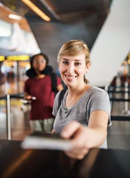 Cropped portrait of an attractive young woman handing over her passport at a boarding gate in an airport.