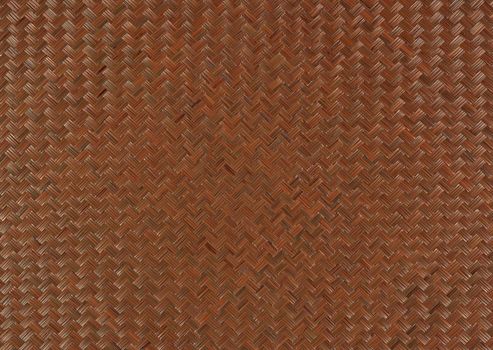 Weaving a rug with a zigzag pattern of brown color close-up