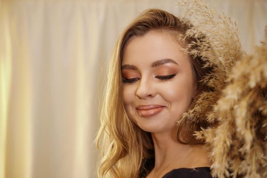 Beautiful young blonde woman face closeup portrait in studio on a light background.