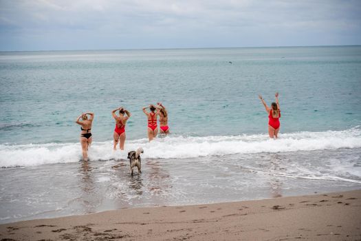 Big happy family or group of five friends is having fun against sunset beach. Beach holidays concept