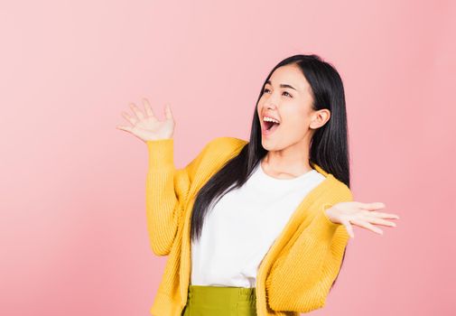 Happy Asian portrait beautiful cute young woman standing winning and surprised excited screaming open mouth raise hands, studio shot isolated pink background, Thai female wow with copy space