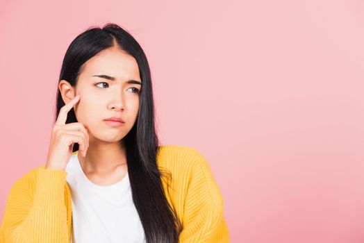 Portrait Asian beautiful young woman standing chin handle relaxed thinking about something about the question studio shot isolated on pink background, Thai female idea think with copy space